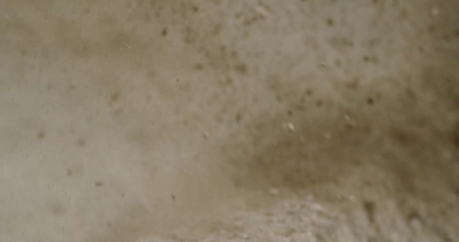 Bike stirs up dirt as it is being ridden by a man