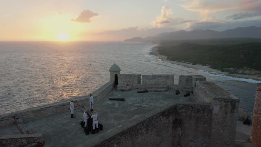 Several people stand on a structure planning to fire a cannon
