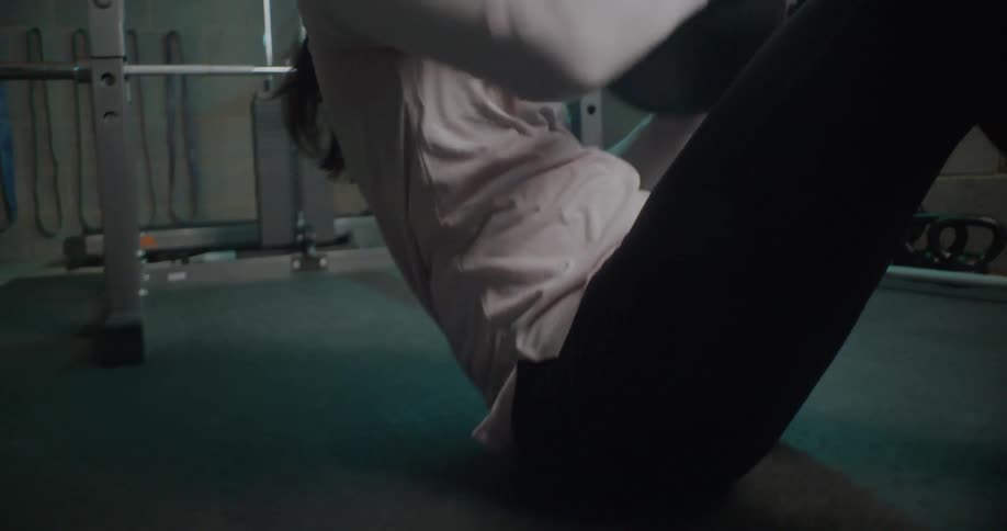 A woman is working out in the gym with a medicine ball