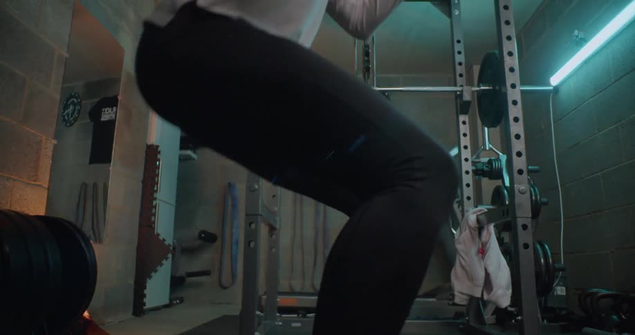 A person is doing crouches in the gym