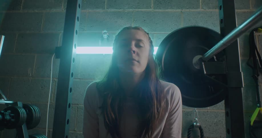 Woman sits on a weight machine in a gym