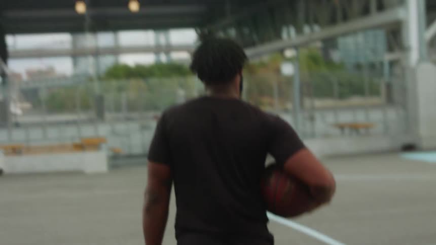A man carries a basketball on the court