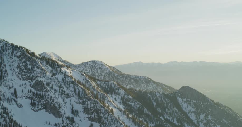 Sunlight shines on snowy mountains at sunset