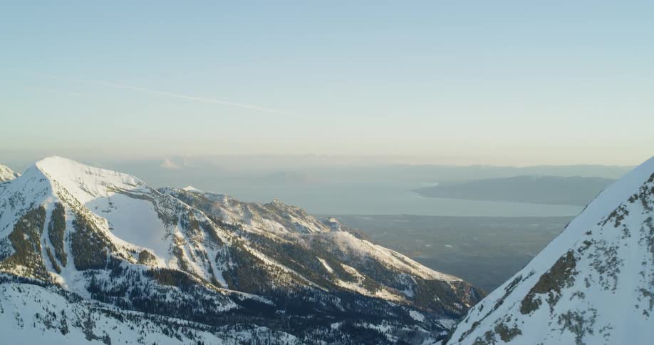 Snow covered mountains sit under a bright blue sky
