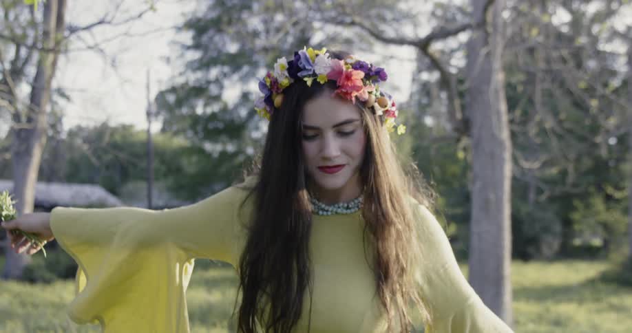 Woman wears a flower wreath outside in a field