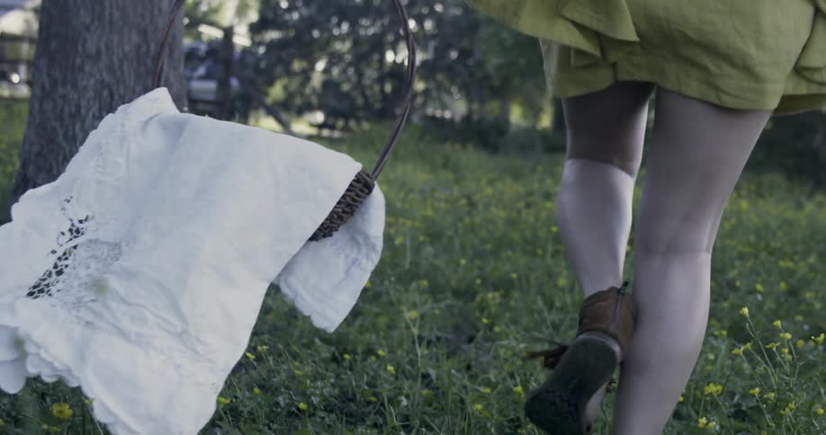 Person walking through the woods carrying a basket