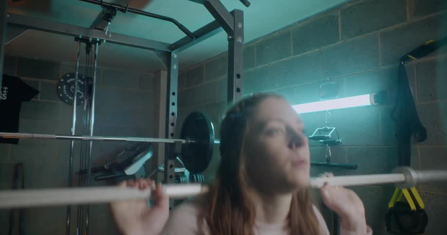 Woman does squats in a weight room