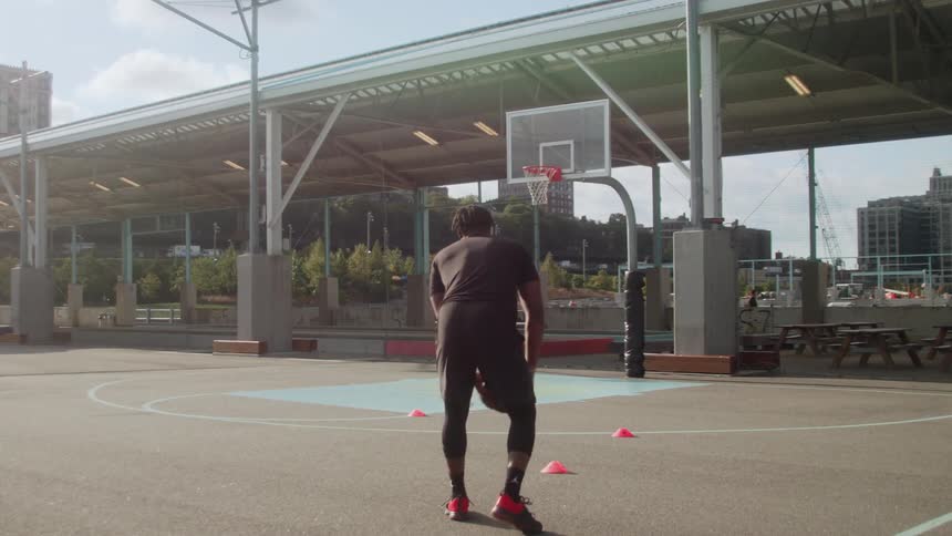 Man dribbles a basketball on a court