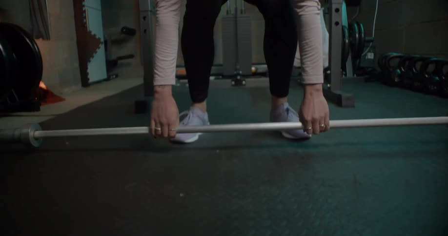 Person sits a barbell down on the floor
