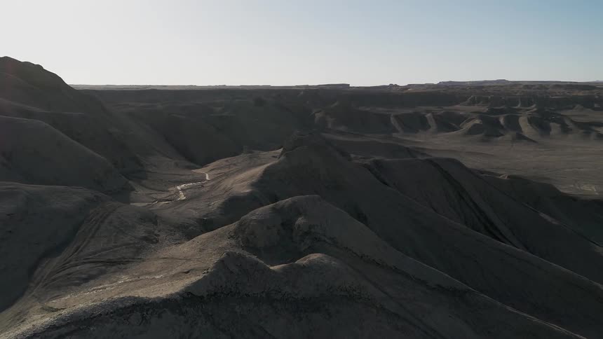 Dirt hills and mountains cover a desert landscape