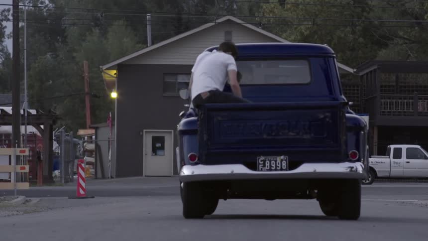 Man jumps into the back of a pickup truck