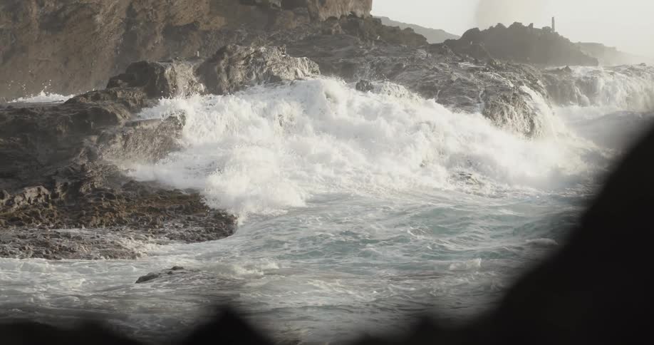 Ocean waves crash into a rocky shore