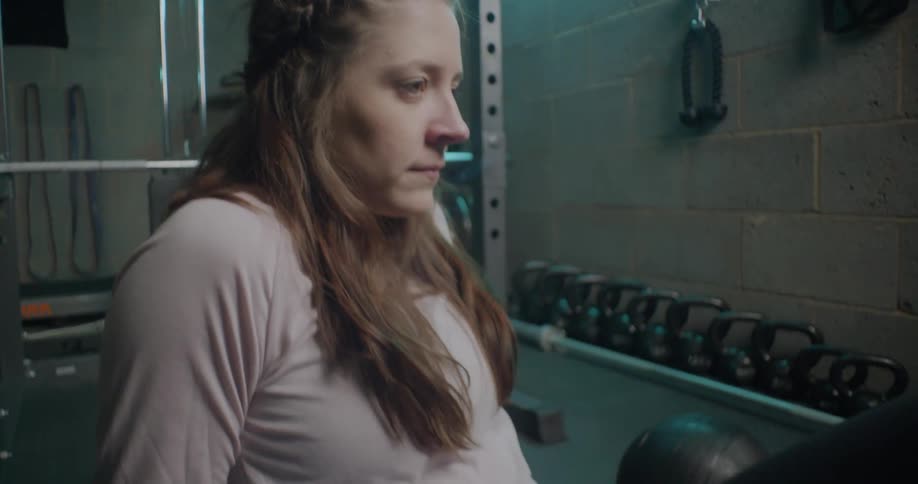 A woman sits in a weight room