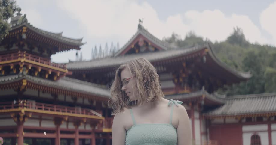 The woman looks to her side on a windy day