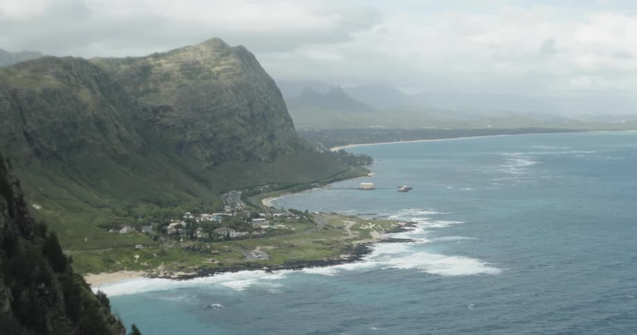 A small village is settled next to a mountain and the ocean