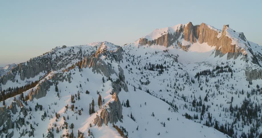 Snow covers a mountain at sunset