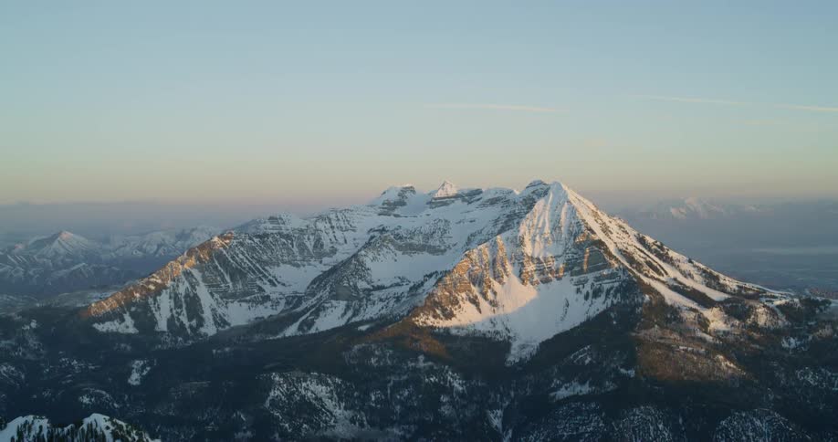 Sun shines on a snow covered mountain peak