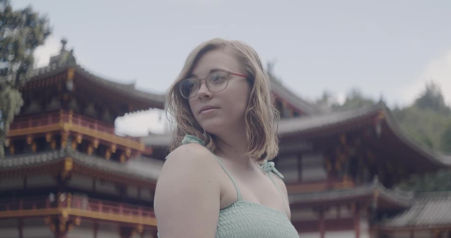 Woman stands in front of pagoda
