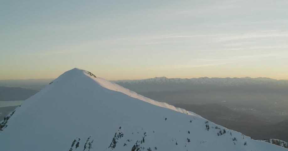 The sun sets over snowy mountains