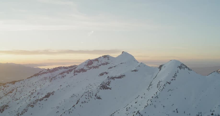 The sun sets over snowy mountains