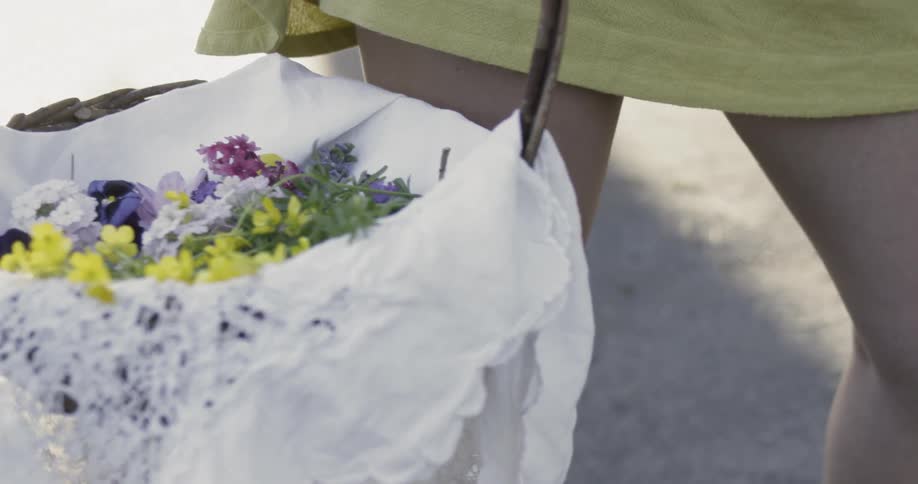 Woman holds a lined basket of fresh flowers