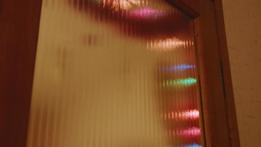 Multicolored lights reflect on a glass door