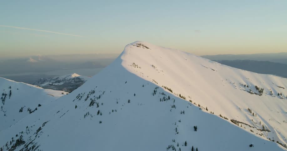 Snow covers mountains at sunset