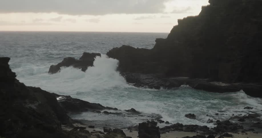 Ocean waves crash to shore on a cloudy day