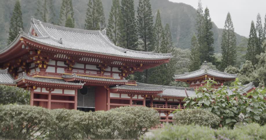 An asian building is surrounded by trees and foliage