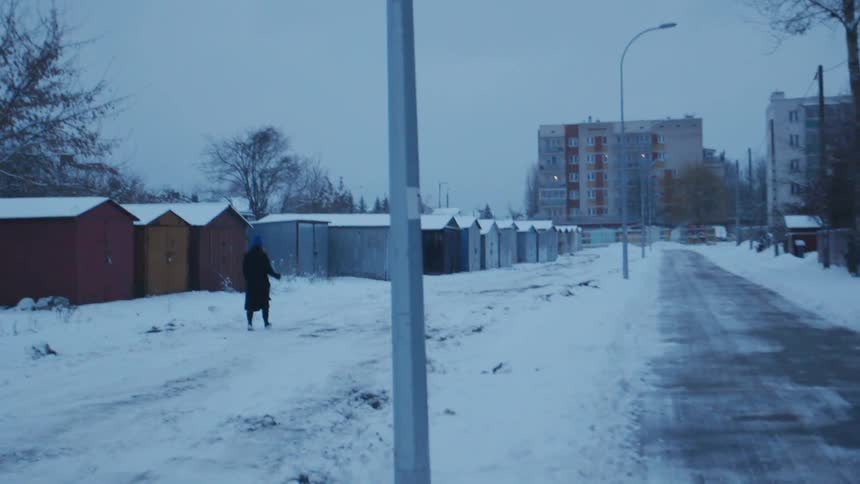 Woman walks on a snowy sidewalk