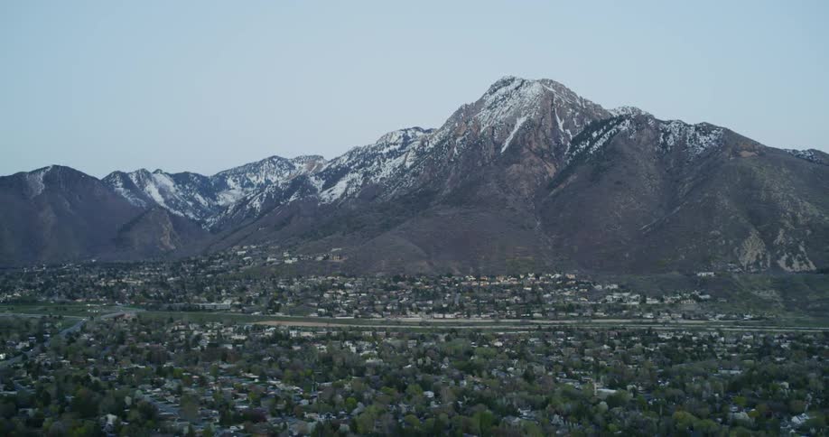A large mountain with a small town in front of it