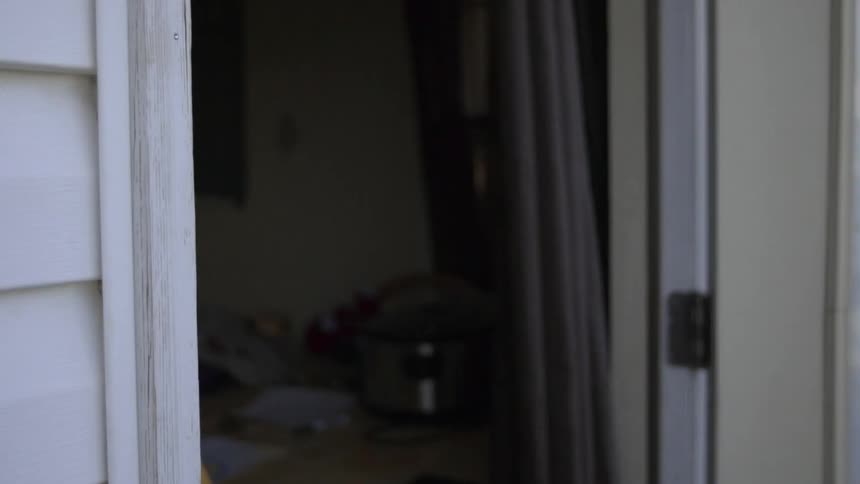 A man runs out the front door of his house