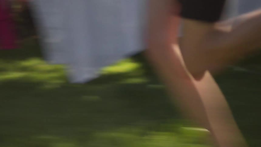 Person running over some grass by houses