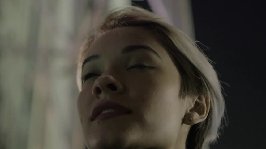 A woman is looking up at lights in the city