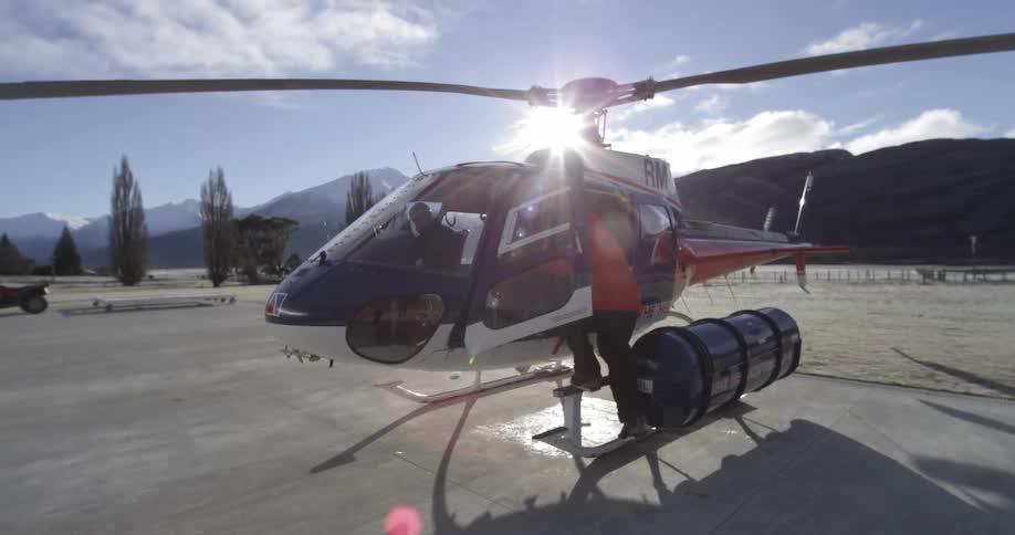 Man walks up to a helicopter and gets in