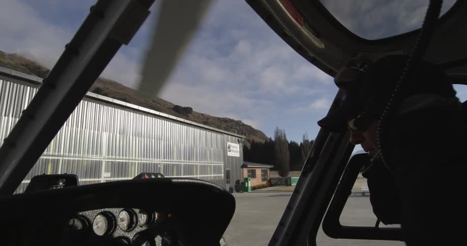 A man in a helicopter puts on his headset
