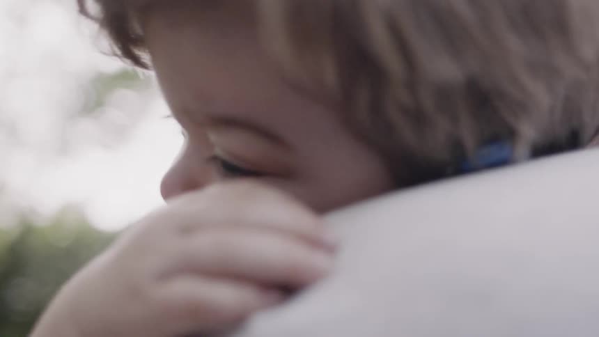 Adult carries a toddler outside
