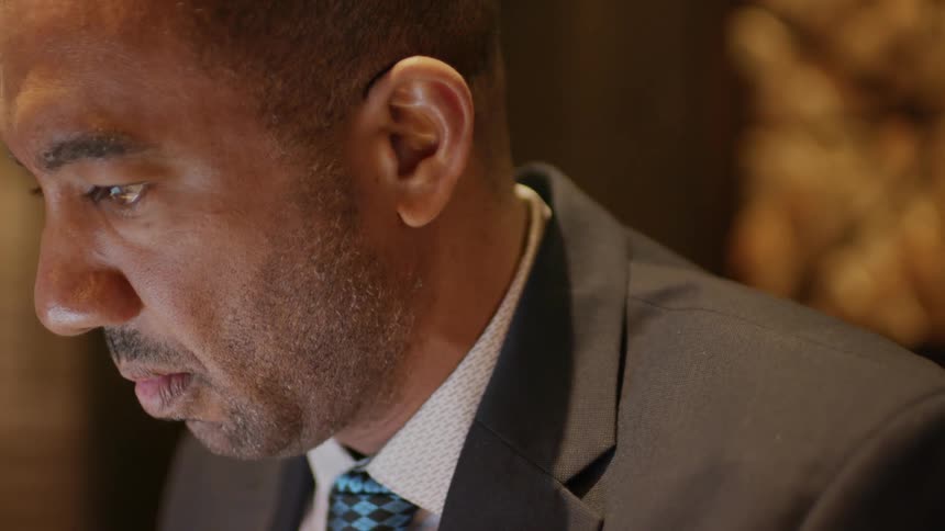 Man wearing a suit blinks as he thinks