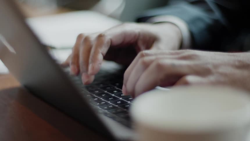 A man works on a laptop at a conference table