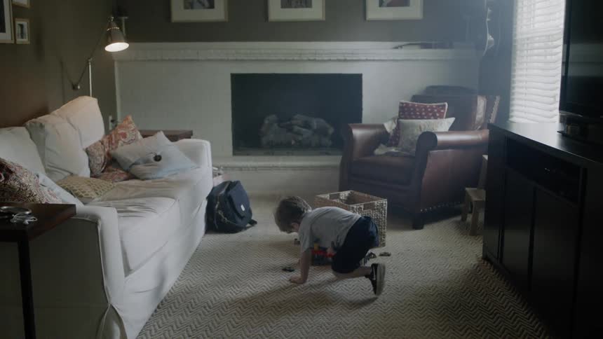 Young boy plays on a living room floor