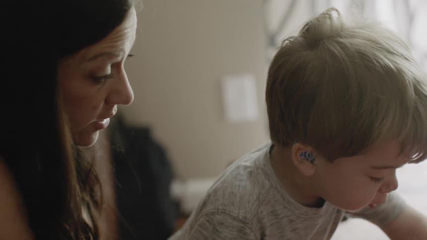 Woman talks to a toddler in a house
