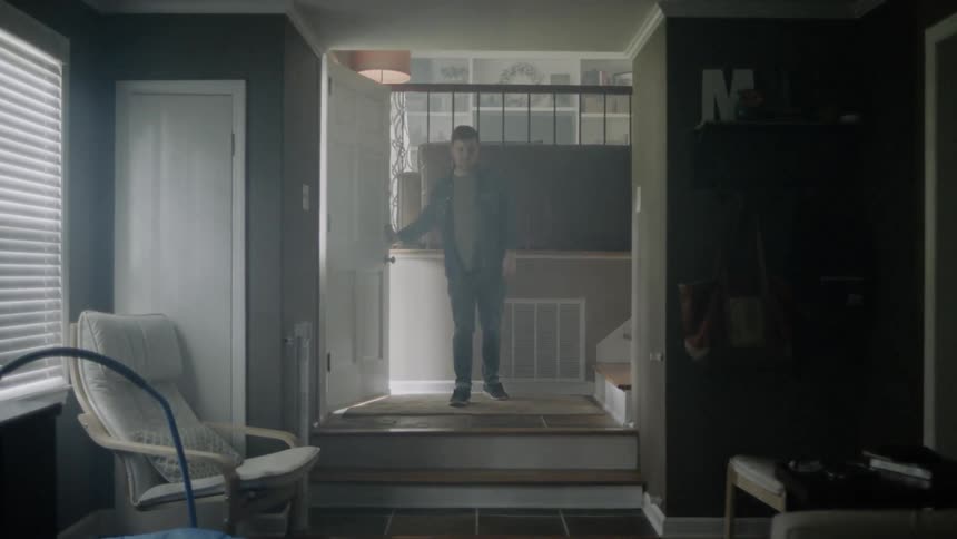Man opens door and enters a house then crosses his arms in front of his chest