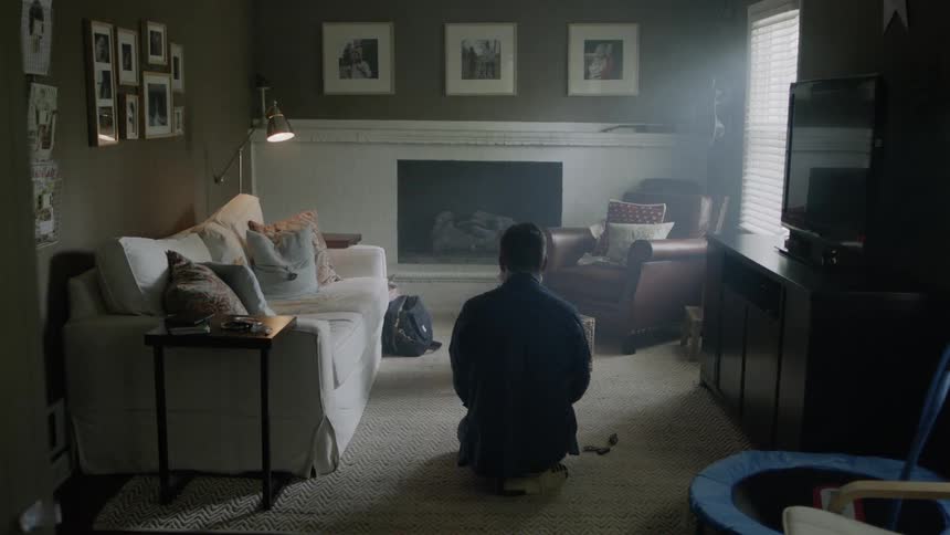 Someone is sitting on the floor in the middle of a living room