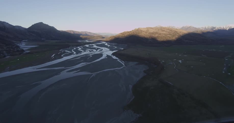 Aerial view of a dry river bed between hills in the morning