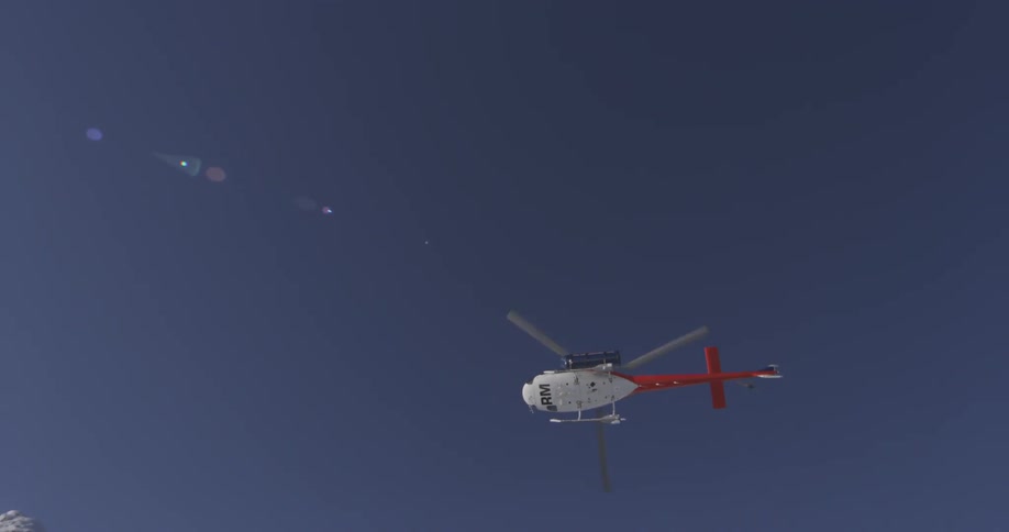 A helicopter taking off in snowy mountains