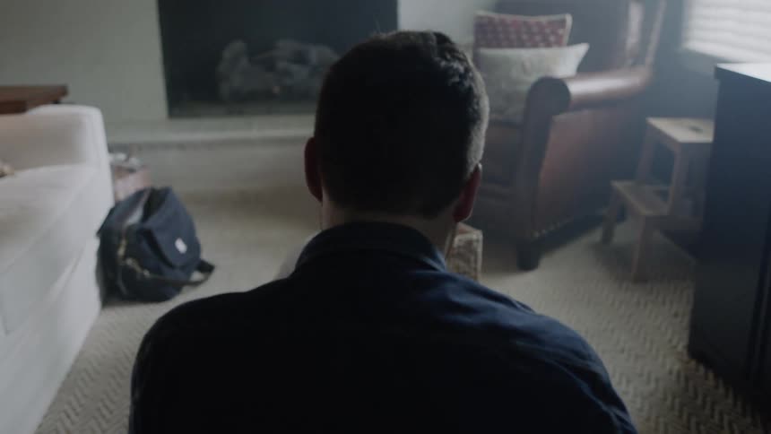 Man sits in the living room as a child sits on the floor