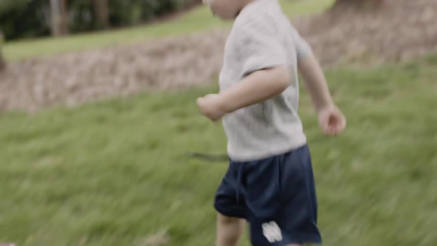 A child walks over to a toy and steps on a pedal