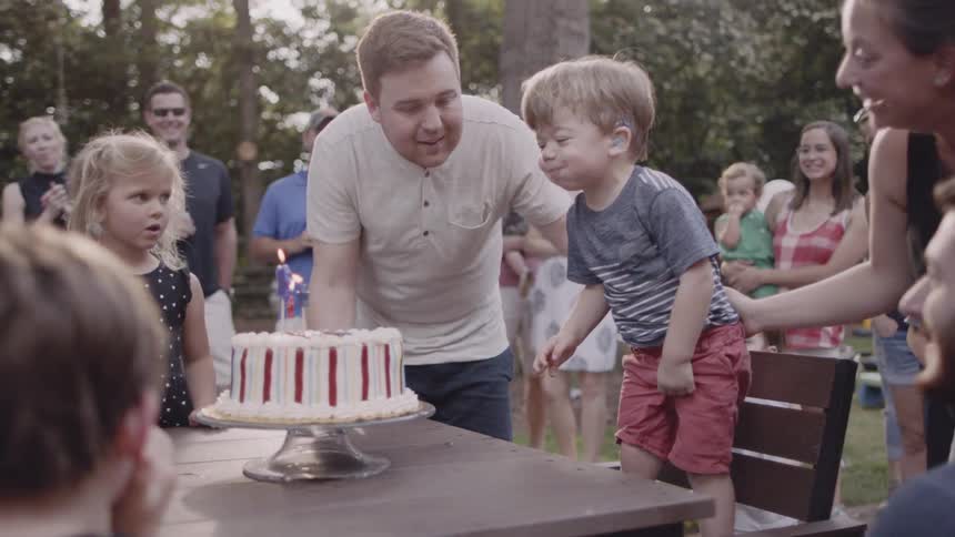 Small boy at birthday party prepares to blow out candles