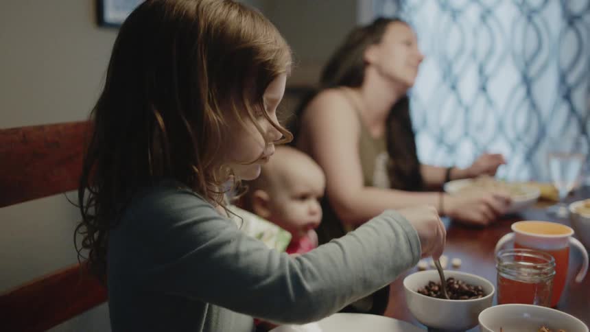 A family is sitting around a table eating dinner