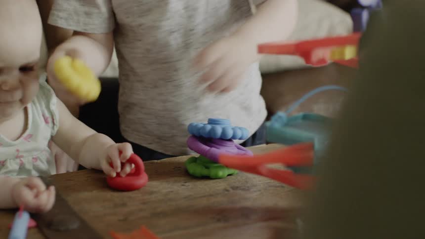 Young toddler and a baby play with some toys